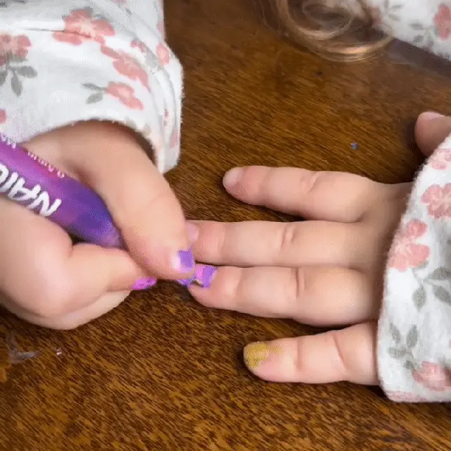 Little girl using nail art pen